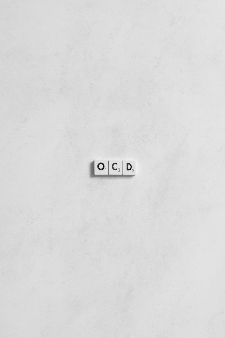 Minimalist OCD Concept on White Background Scrabble tiles spelling "OCD" on a white background